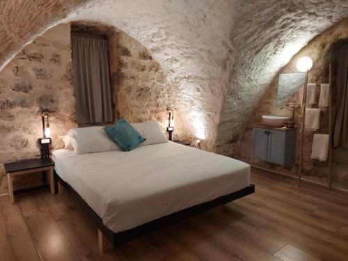 1 dormitorio con 1 cama en una habitación de piedra con lavamanos en Tel-Aviv LALA Boutique Hotel, en Tel Aviv
