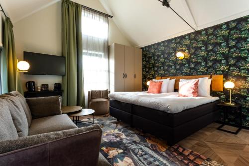 a hotel room with a bed and a couch at Boutique Hotel Rijks I Kloeg Collection in Goes