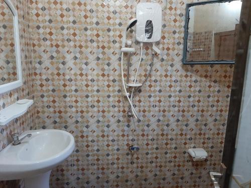 La salle de bains est pourvue d'une douche et d'un lavabo. dans l'établissement Villa Chambre B climatisée douche Cuisine salon, à Bamako