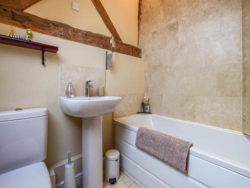 a bathroom with a sink and a toilet and a bath tub at Owl's End, Oosland Farm in Bidford