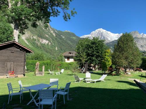 a picnic table and chairs in a field with mountains at Hameau De Jadis in Pré-Saint-Didier