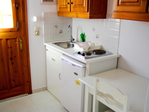 a small kitchen with a sink and a stove at Elena Studios & Apartments in Piso Livadi
