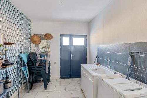 a bathroom with a sink and a blue door at Gentiane in Saint-Amandin