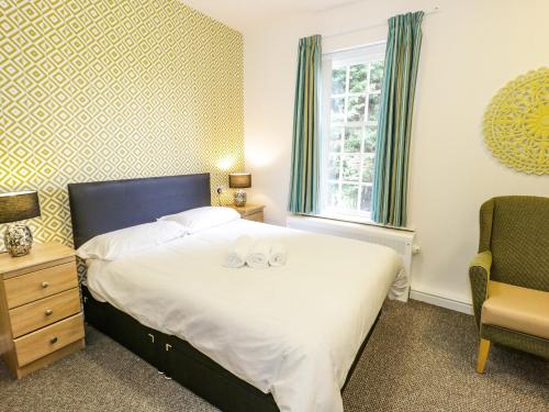 a bedroom with a bed with two towels on it at Plas Coch in St Asaph