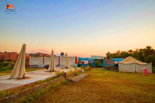 a group of tents and umbrellas in a field at Nuba Narty in Aswan