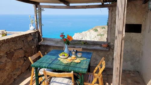 a table and chairs on a balcony with a view of the ocean at Case di Berto in Capo Vaticano