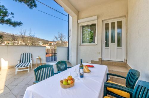 a table with a basket of fruit on a patio at Seaside Guesthouse by JR City Apartments in Jadranovo
