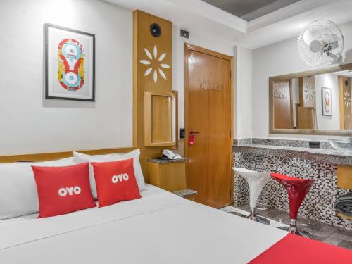 Habitación de hotel con cama con almohadas rojas en OYO Estrela Dalva, São Paulo, en São Paulo
