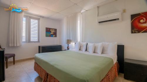 um quarto com uma cama grande num quarto em Sandy Beach Hotel em San Juan