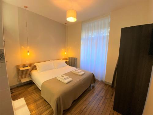 a bedroom with a bed with two towels on it at Appartements Rue Sarret XXL in Angers