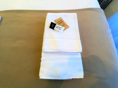 a white towel sitting on top of a bed at Appartements Rue Sarret XXL in Angers