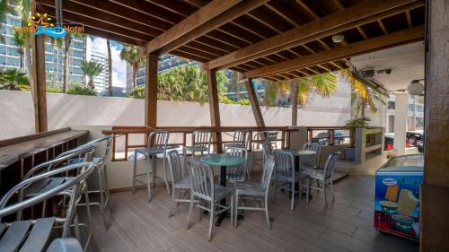a restaurant with tables and chairs on a patio at Sandy Beach Hotel in San Juan