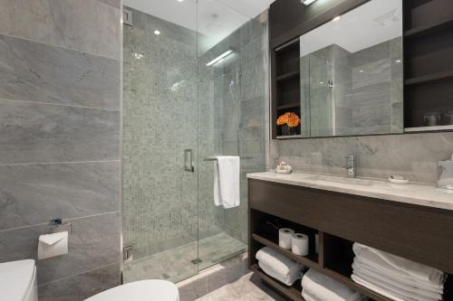 a bathroom with a shower and a toilet and a sink at SOHO Residences Lisgar in Ottawa
