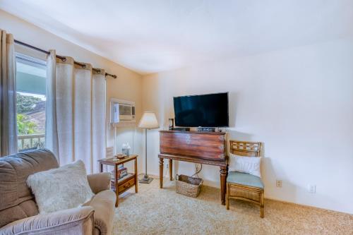 sala de estar con piano y TV en Kihei Kai 12, en Kihei