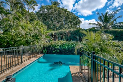 una piscina con una valla y palmeras en Kihei Kai 12, en Kihei