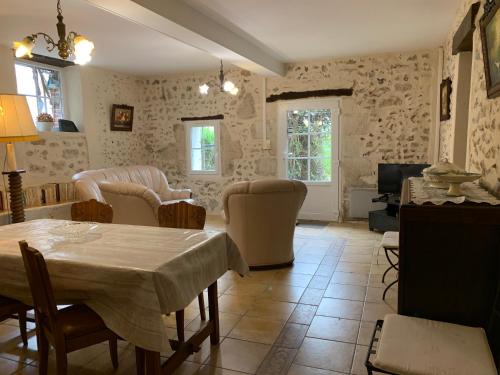 un salon avec une table et des chaises dans l'établissement Gites de la Thiau, à Briare
