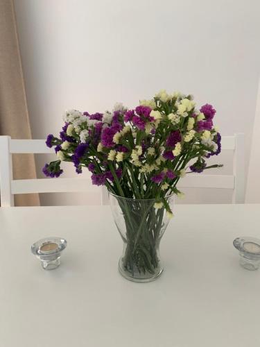a vase filled with purple and white flowers on a table at CHINASOLYMAR LUXURY - Con Parking in Almuñécar