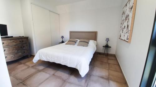 une chambre avec un lit blanc avec deux oreillers dans l'établissement Le Nid Discret avec Balcon et parking privé gratuit, à Sarlat-la-Canéda