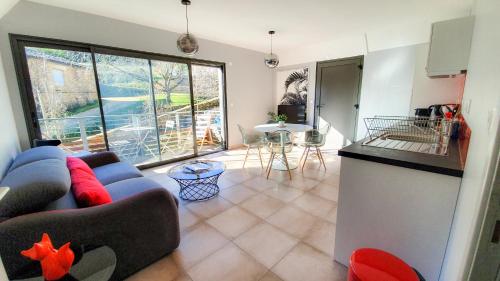 un salon avec un canapé bleu et une cuisine dans l'établissement Le Nid Discret avec Balcon et parking privé gratuit, à Sarlat-la-Canéda