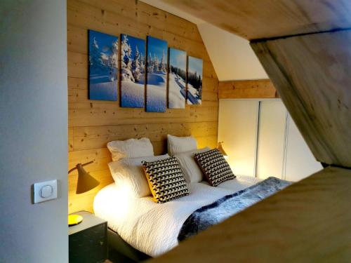 Un dormitorio con una cama en una pared de madera. en L'étang de la Tourne, en Les Marches
