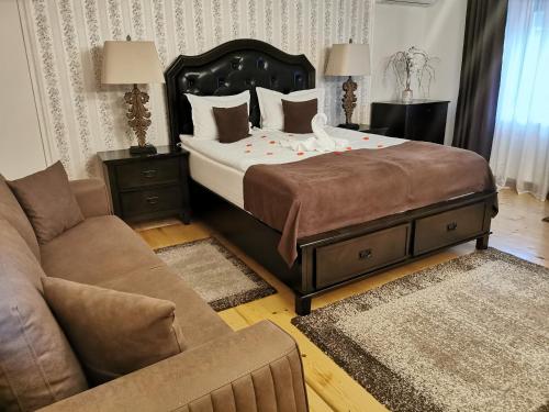 a bedroom with a large bed and a couch at Select House in Sibiu