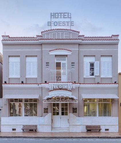 a building with a hotel guest sign on top of it at MOVA Hotel D'oeste - Localizado em frente a Praça Principal da Cidade, na área Central - Pé na Praça in Poços de Caldas
