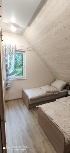 Cette chambre comprend 2 lits et une fenêtre. dans l'établissement EkoGaik, à Lewin Kłodzki