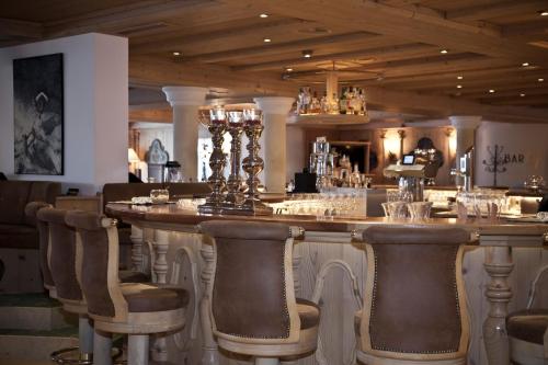 a bar with bar stools in a restaurant at Superior Hotel Post Ischgl in Ischgl