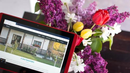 a computer monitor sitting next to a bouquet of flowers at Pensiunea Tara Fagilor in Suceava