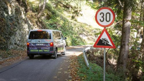 a van driving down a road with a speed limit sign at Pensiunea Tara Fagilor in Suceava