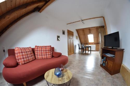 sala de estar con sofá rojo y TV en Anhalter Berg en Quedlinburg