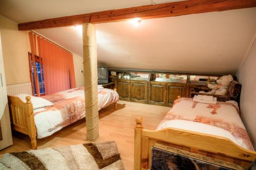1 dormitorio con 2 camas y TV. en Guest House Angelkovi en Sapareva Banya