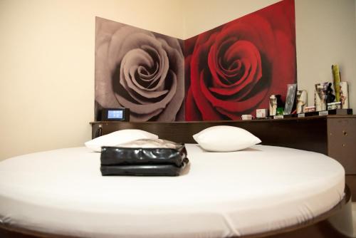 a black purse sitting on a white bed with a painting at Prime Motel Campinas in Campinas