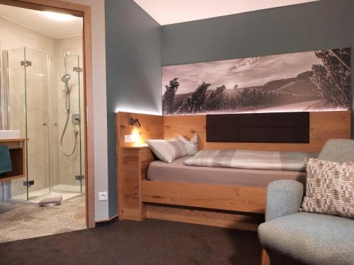 a bedroom with a bed with a large painting on the wall at Landpension Kohler in Brackenheim