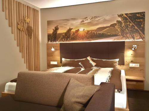 a bedroom with a bed with a painting on the wall at Landpension Kohler in Brackenheim