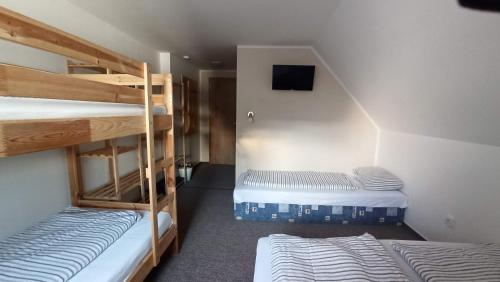 a room with two bunk beds and a tv at Penzion a restaurace V Háji in Loučná pod Klínovcem