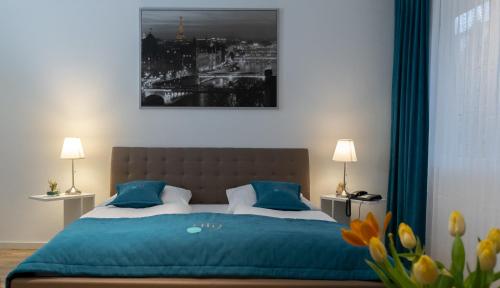 a bedroom with a bed with blue sheets and blue pillows at Friends Hotel Bad Salzuflen in Bad Salzuflen