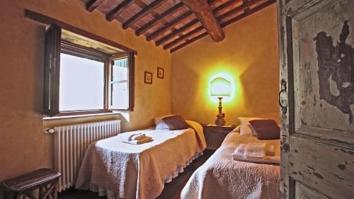 a room with two beds and a window at L'Ormasso in Pieve Fosciana