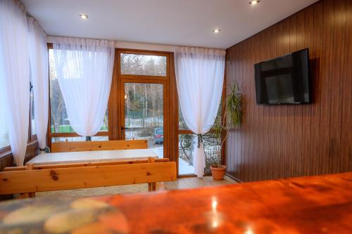 a living room with two benches and a flat screen tv at Guest House Angelkovi in Sapareva Banya