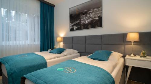 two beds in a hotel room with blue and white at Friends Hotel Bad Salzuflen in Bad Salzuflen
