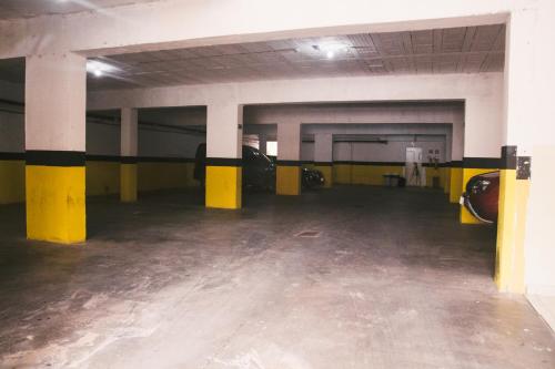 an empty parking garage with yellow and black columns at Hotel do Papa in Aparecida