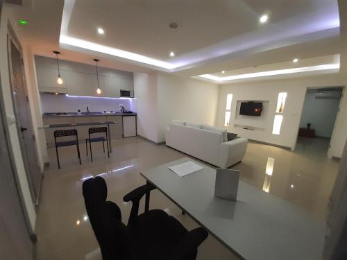 een woonkamer met een witte bank en een tafel bij Apto T1 Sweet Home in Praia