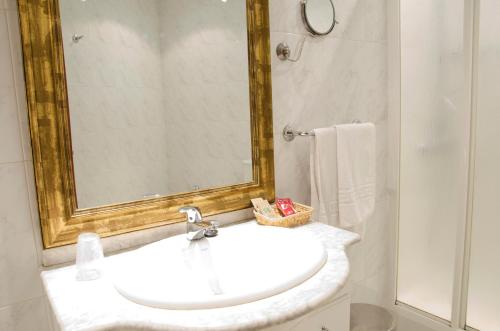 een badkamer met een witte wastafel en een spiegel bij Hotel Algete in Algete