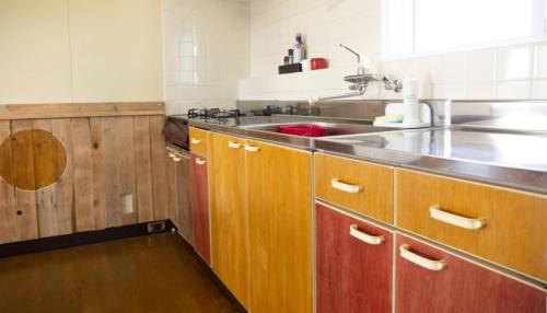 una cocina con armarios de madera y fregadero en Maeda Forestry House - Vacation STAY 19184v, en Furano