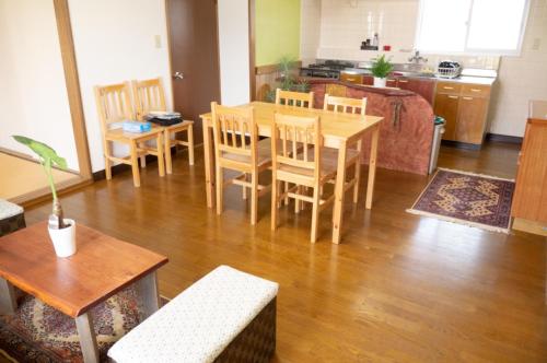 sala de estar con mesa y sillas y cocina en Maeda Forestry House - Vacation STAY 19585v, en Furano