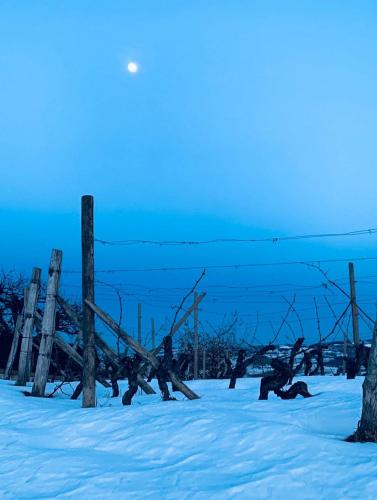 a fence in the snow with the moon in the sky at Casa di Dario in Diano dʼAlba