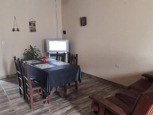 comedor con mesa, sillas y TV en COMPLEJO DE DPTOS EN RAFAELA a pasitos de la RUTA 34 en Rafaela