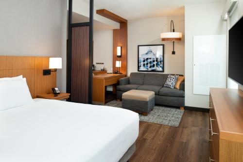 a hotel room with a bed and a couch at Hyatt Place Dallas/Rockwall in Rockwall