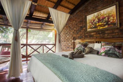 a bedroom with a bed and a painting on the wall at Doringpoort Lodge in Marloth Park