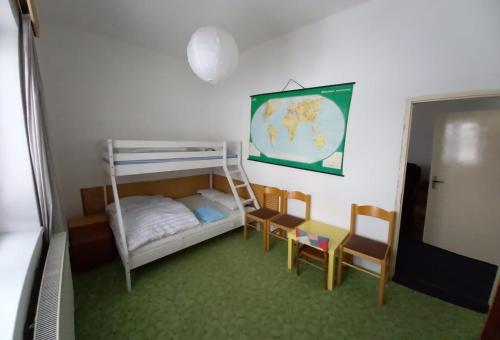 niewielka sypialnia z łóżkiem piętrowym i krzesłami w obiekcie Apartmán Saxán Smržovka w mieście Smržovka